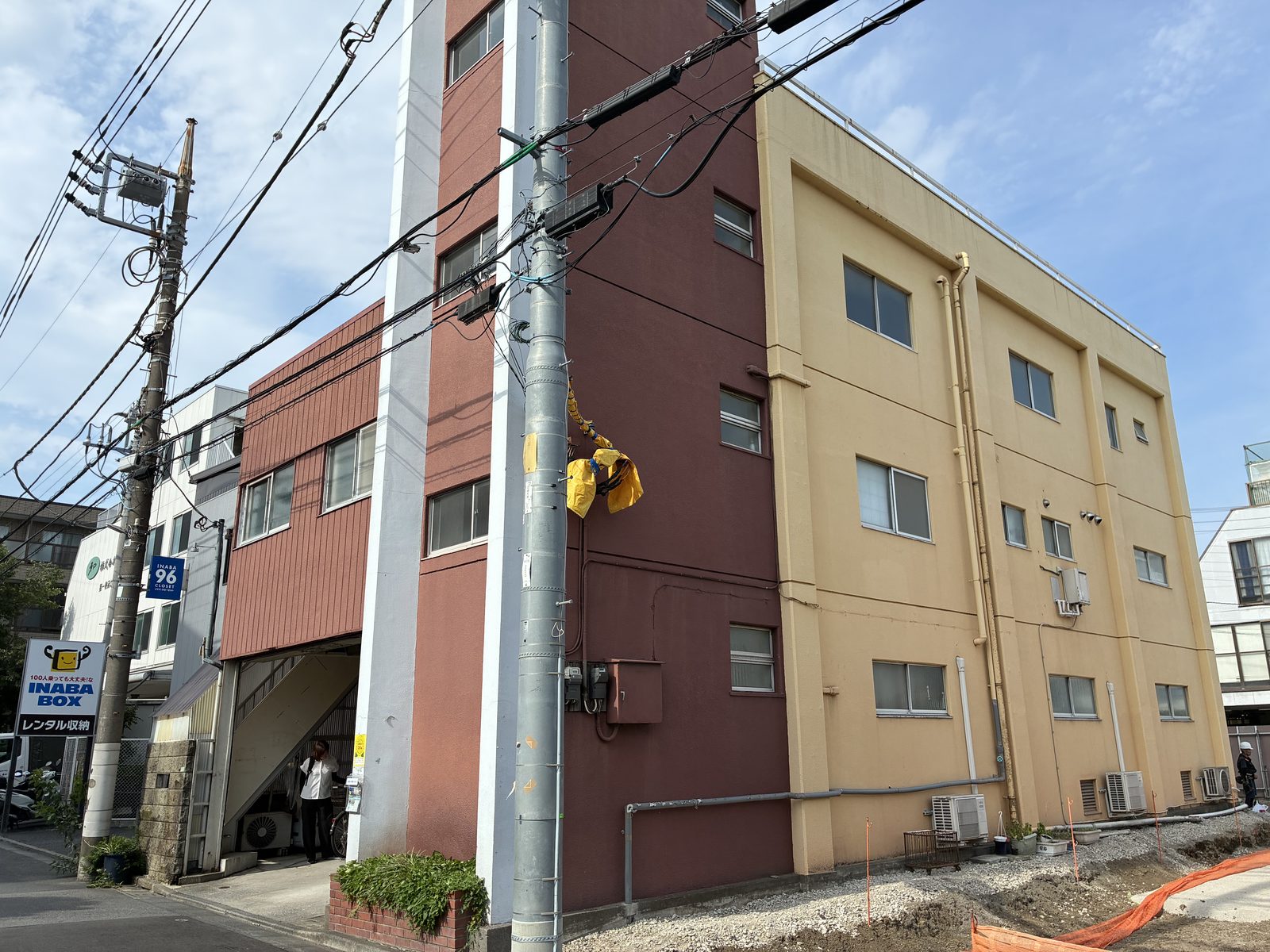 えんじ色と黄土色の壁が並ぶ三階建てのビルの外観